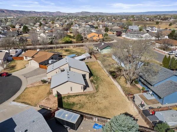 an aerial view of residential houses with outdoor space and parking