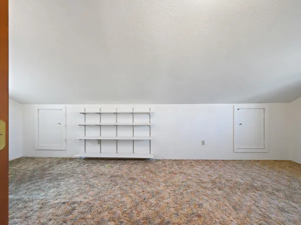 a view of livingroom with kitchen and white cabinets