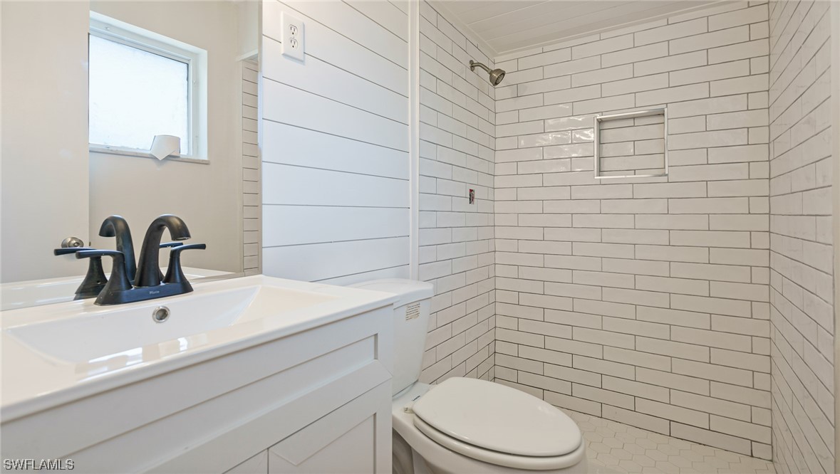 8631 Exeter Street Fort Myers, FL 33907 - Photo 12 of 23 a bathroom with a toilet a sink a mirror and vanity