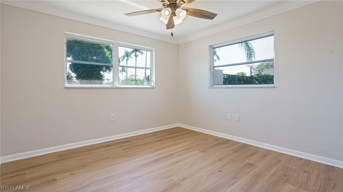 8631 Exeter Street Fort Myers, FL 33907 - Photo 13 of 23 wooden floor in an empty room with a window