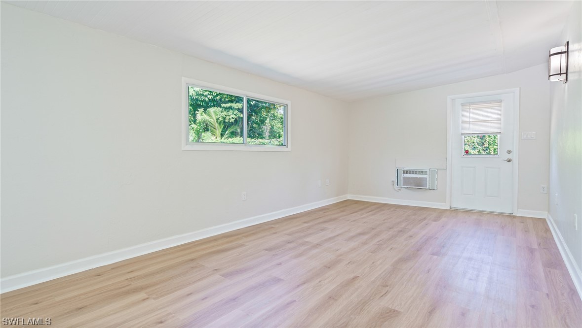 8631 Exeter Street Fort Myers, FL 33907 - Photo 16 of 23 an empty room with wooden floor and windows