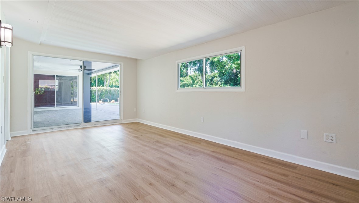8631 Exeter Street Fort Myers, FL 33907 - Photo 17 of 23 an empty room with wooden floor and windows