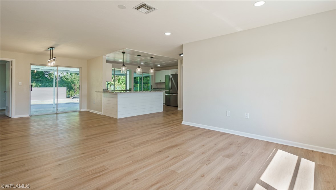 8631 Exeter Street Fort Myers, FL 33907 - Photo 5 of 23 an empty room with wooden floor and windows