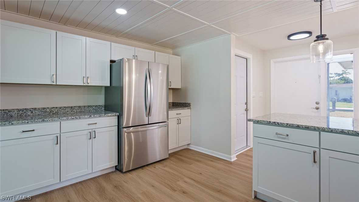 8631 Exeter Street Fort Myers, FL 33907 - Photo 9 of 23 a kitchen with granite countertop white cabinets and stainless steel appliances