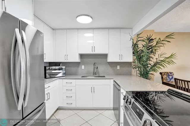 a kitchen with stainless steel appliances granite countertop a refrigerator sink and stove