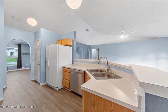 a kitchen with stainless steel appliances granite countertop a sink and a refrigerator
