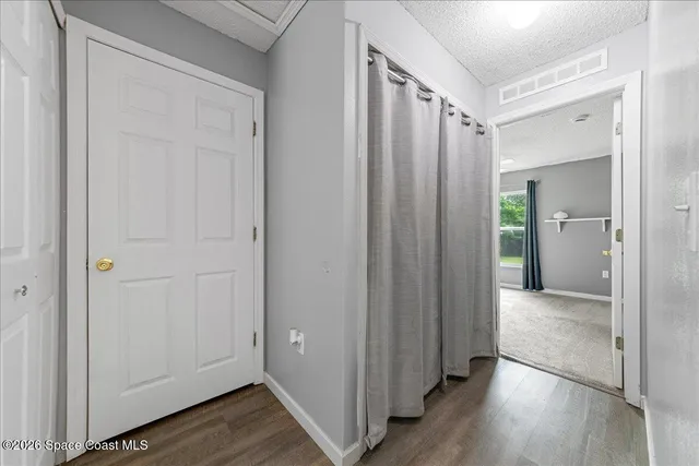 a view of a hallway with wooden floor