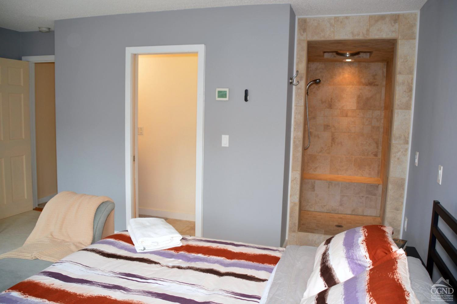 81 Scribner Hollow Road, Unit D 2 Hunter, NY 12442 - Photo 18 of 36 a bedroom with a bed and a chair