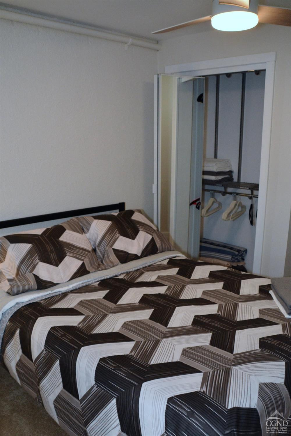 81 Scribner Hollow Road, Unit D 2 Hunter, NY 12442 - Photo 20 of 36 a bedroom with a bed and a mirror