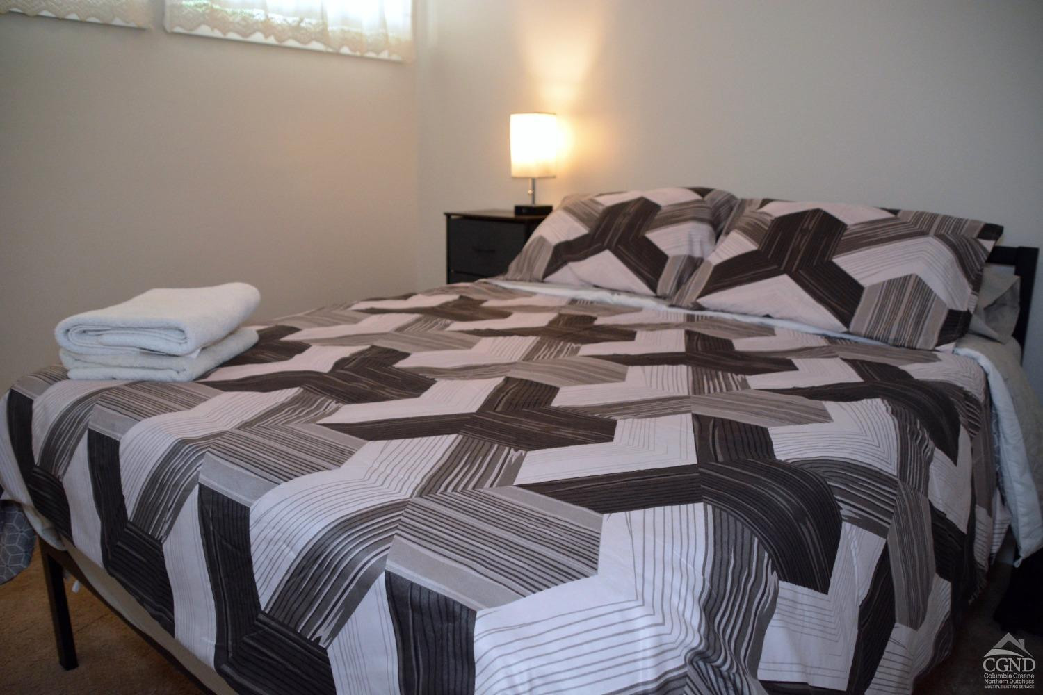 81 Scribner Hollow Road, Unit D 2 Hunter, NY 12442 - Photo 21 of 36 a bedroom with a bed and wooden floor