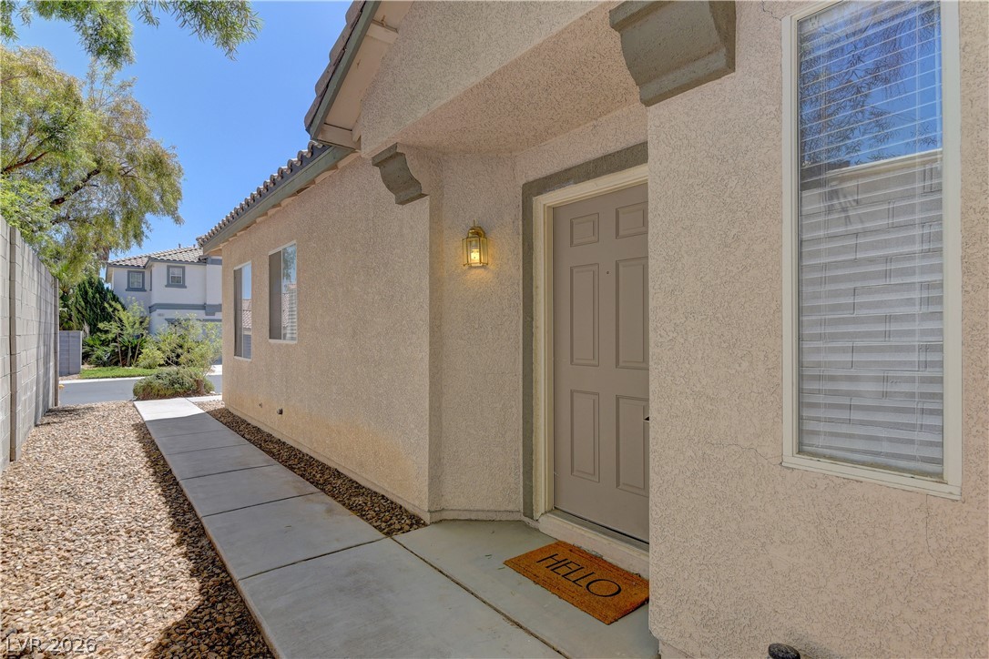 4613 Rising Cove Street Las Vegas, NV 89129 - Photo 2 of 20 Welcome to a charming residence featuring a sturdy stucco exterior and a convenient paved walkway.