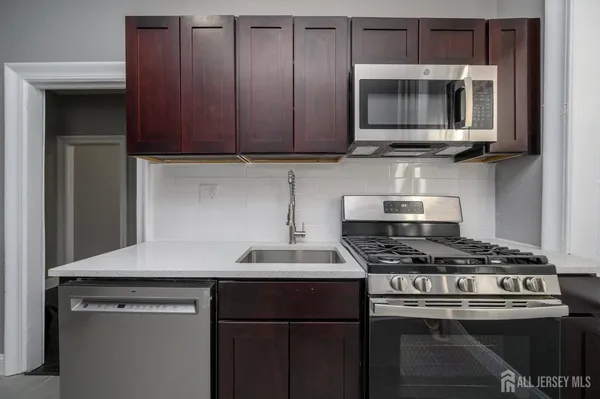 a kitchen with stainless steel appliances a stove a microwave and sink