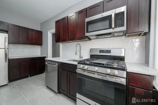 a kitchen with stainless steel appliances wooden cabinets and a stove top oven