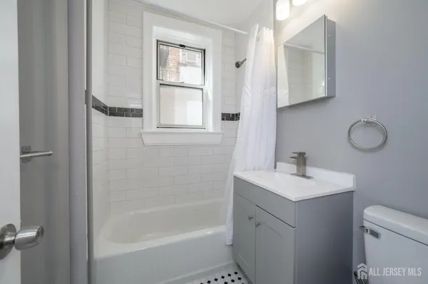 a bathroom with a sink toilet vanity and tub