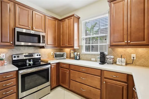 a kitchen with granite countertop cabinets stainless steel appliances a sink and window