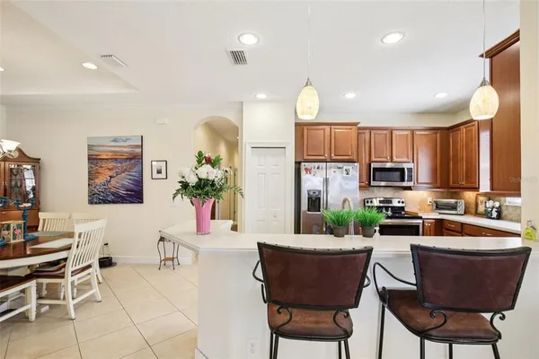 a living room with furniture a large window and kitchen view