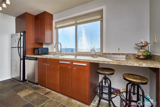 a kitchen with stainless steel appliances granite countertop a sink and a refrigerator