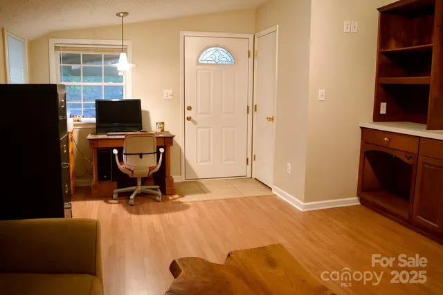 a view of a workspace with furniture and a window