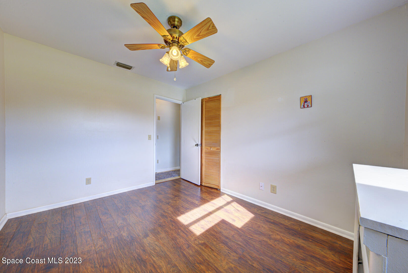 2180 Cindy Circle Melbourne, FL 32935 - Photo 21 of 31 an empty room with wooden floor and windows