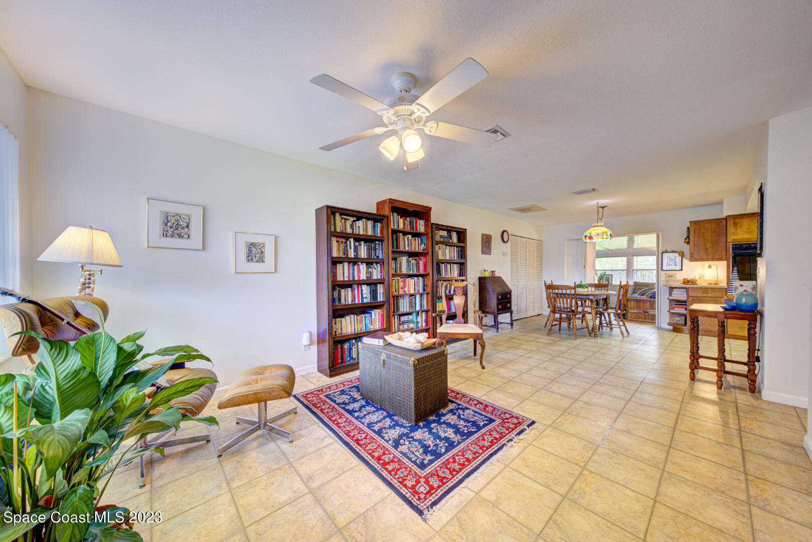 2180 Cindy Circle Melbourne, FL 32935 - Photo 4 of 31 a living room with furniture a bookshelf and a potted plant