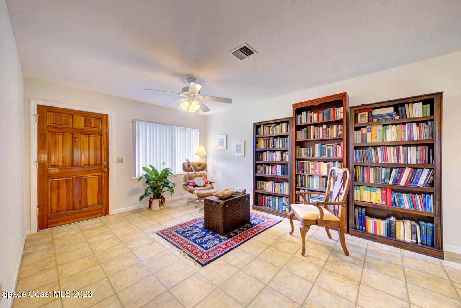 2180 Cindy Circle Melbourne, FL 32935 - Photo 5 of 31 a living room with furniture a bookshelf and a bookshelf