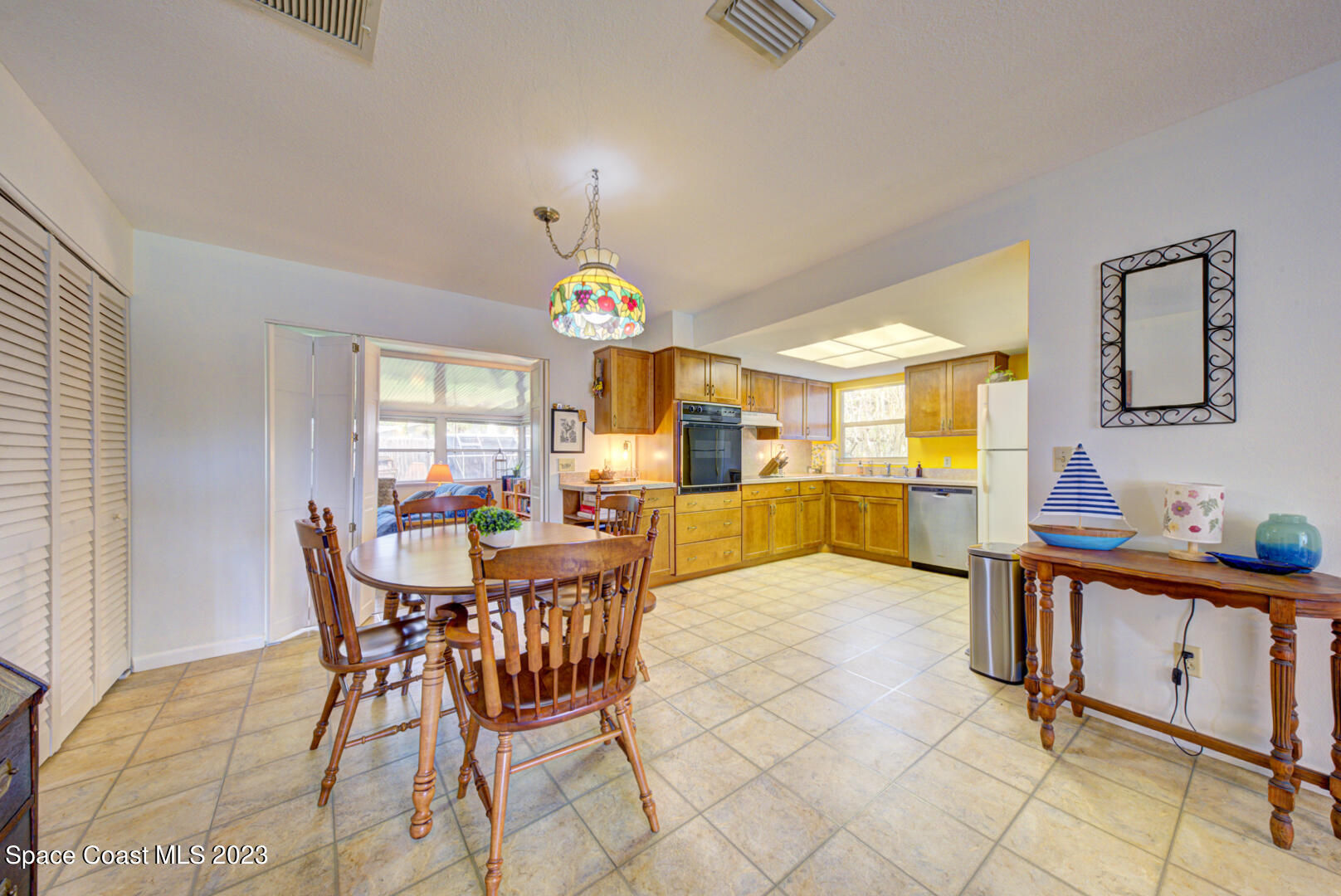 2180 Cindy Circle Melbourne, FL 32935 - Photo 7 of 31 a view of a dining room and livingroom with furniture a rug a fireplace and a chandelier