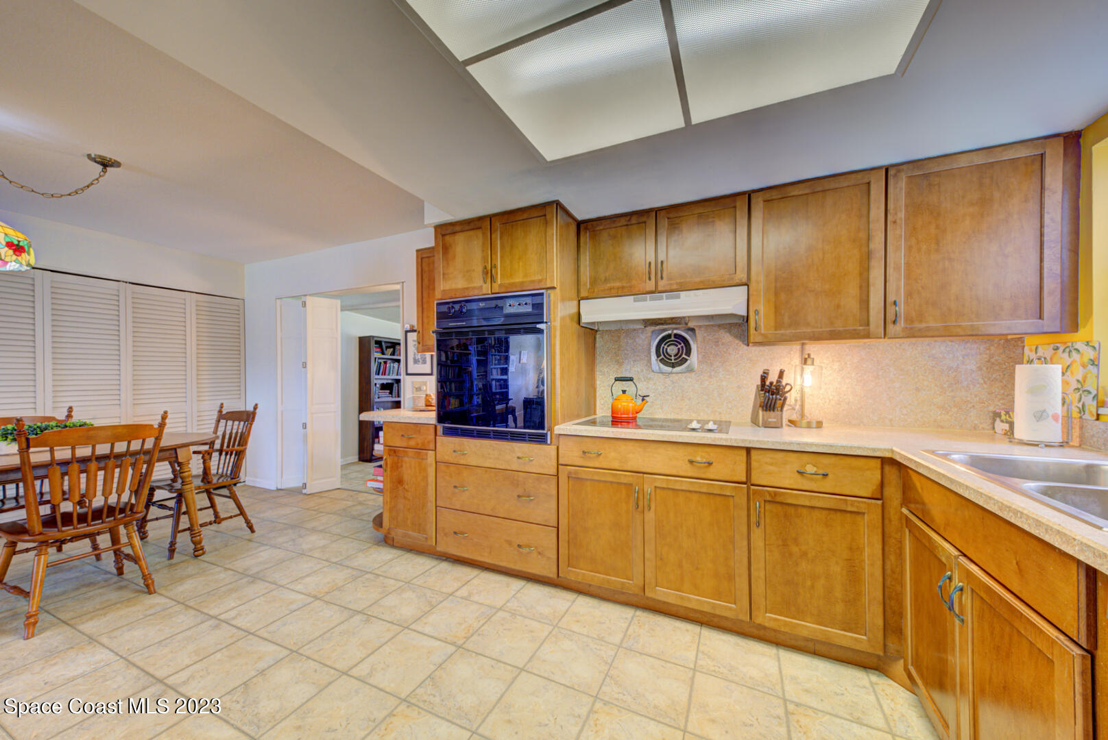 2180 Cindy Circle Melbourne, FL 32935 - Photo 9 of 31 a kitchen with stainless steel appliances wooden cabinets dining table and chairs