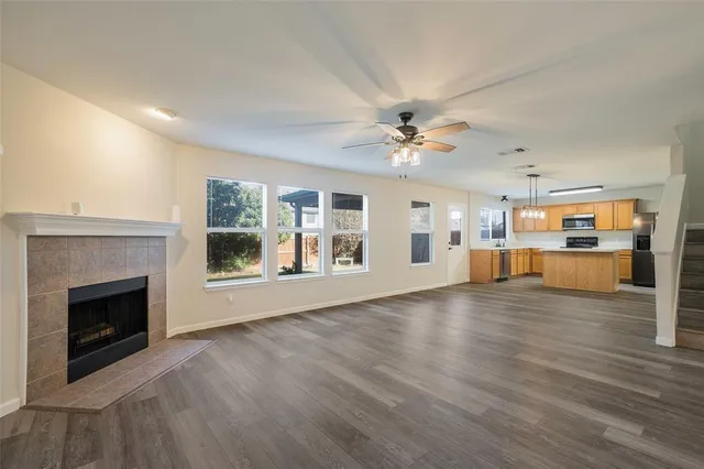 a view of empty room with wooden floor and fireplace