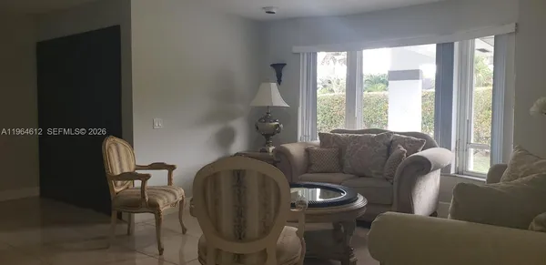 a living room with furniture and a floor to ceiling window