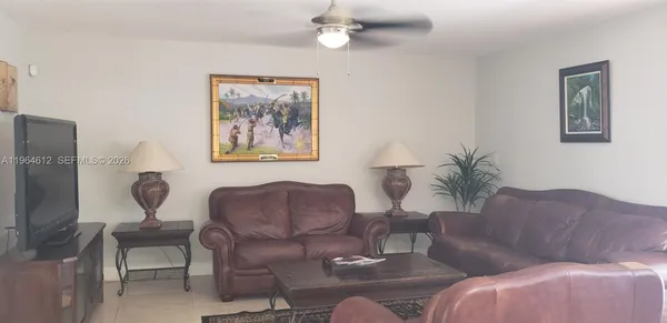 a living room with furniture a large window and a lamp