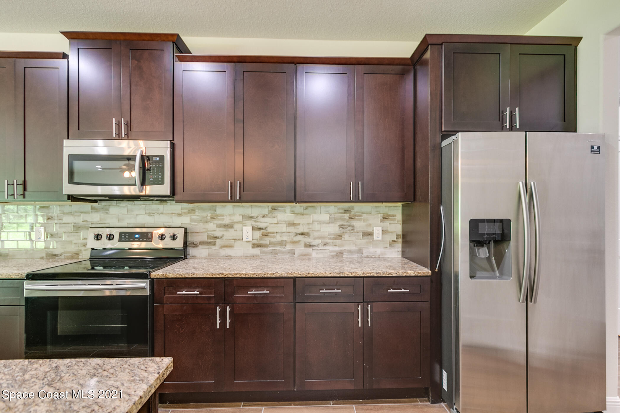 487 Abello Road Southeast, Unit 50 Palm Bay, FL 32909 - Photo 22 of 23 a kitchen with stainless steel appliances granite countertop a refrigerator and a stove top oven