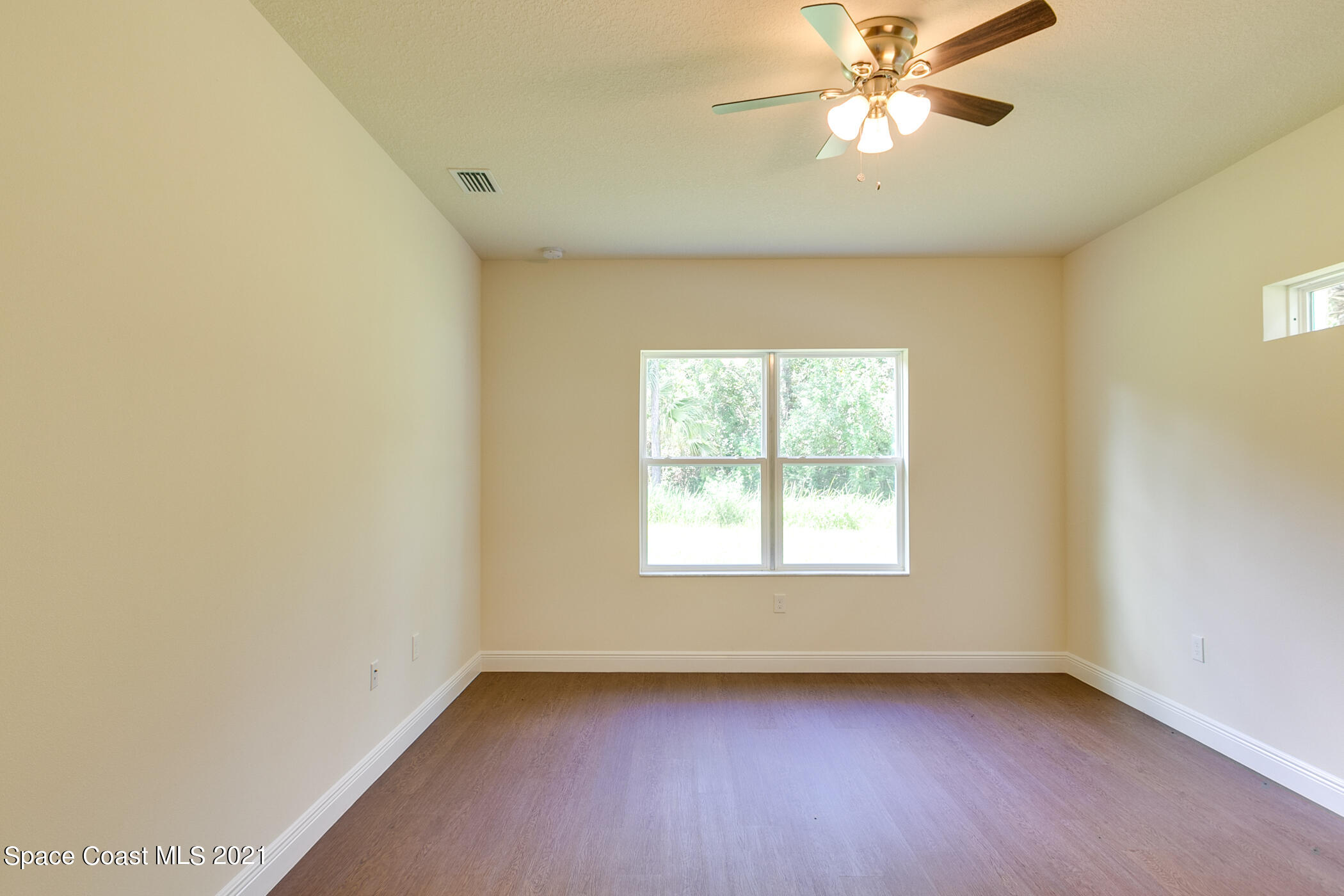 487 Abello Road Southeast, Unit 50 Palm Bay, FL 32909 - Photo 7 of 23 an empty room with a window and a fan