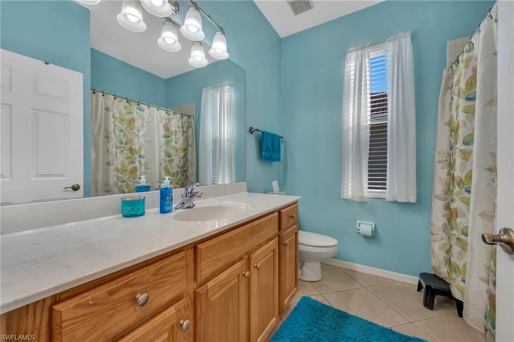 3685 Yosemite Court Naples, FL 34116 - Photo 14 of 16 Full bathroom with vanity, a tub/shower combo, and light tile patterned floors