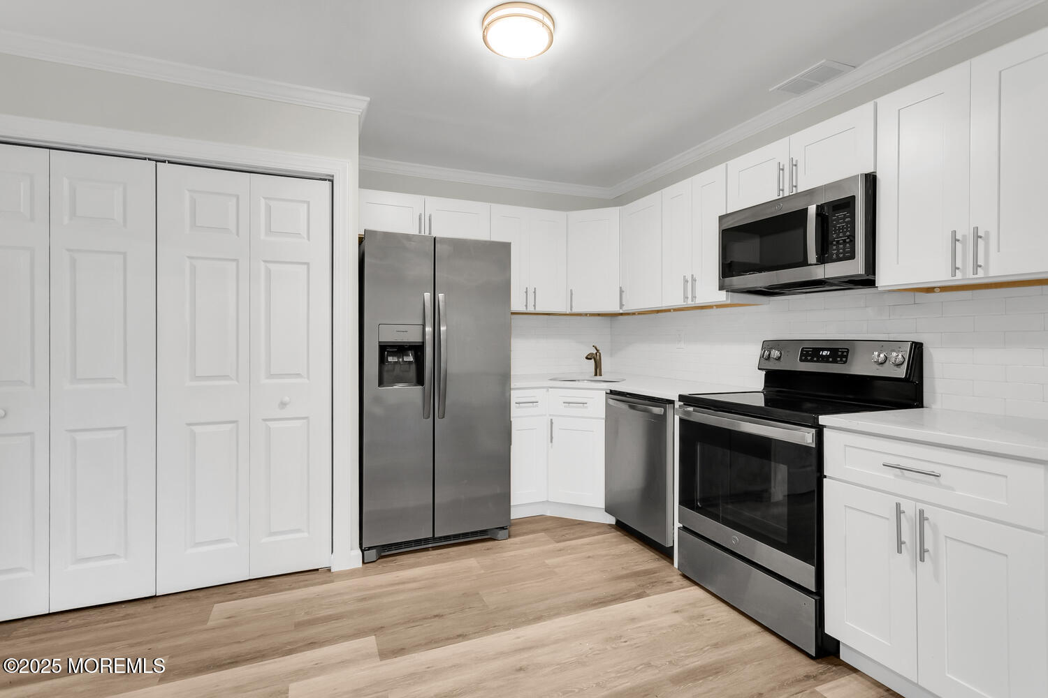 31 Hancock Court Red Bank, NJ 07701 - Photo 2 of 32 a kitchen with stainless steel appliances white cabinets and a refrigerator