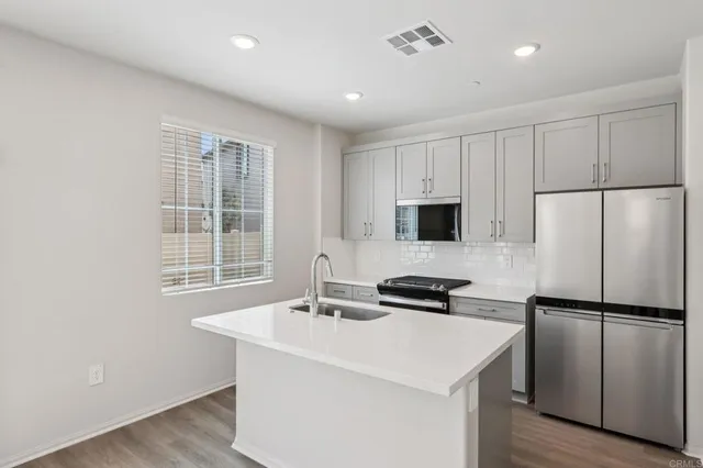 a kitchen with a refrigerator a sink and a stove top oven