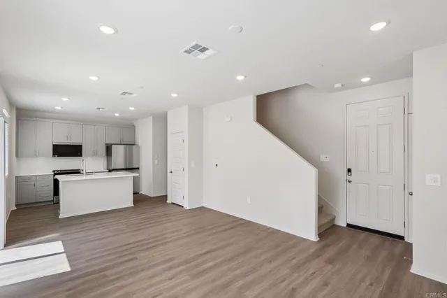 a view of kitchen with kitchen island wooden floors granite counter tops and white stainless steel appliances