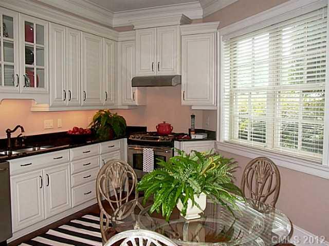2823 Providence Road, Unit 312 Charlotte, NC 28211 - Photo 11 of 16 a kitchen with a chair and white cabinets
