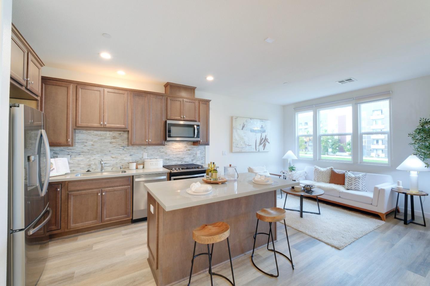 1888 Joshua Tree Circle Milpitas, CA 95035 - Photo 13 of 50 a kitchen with stainless steel appliances granite countertop a stove top oven a sink dishwasher a dining table and chairs with wooden floor