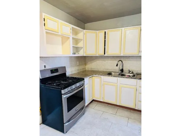 a kitchen with granite countertop a stove sink and cabinets