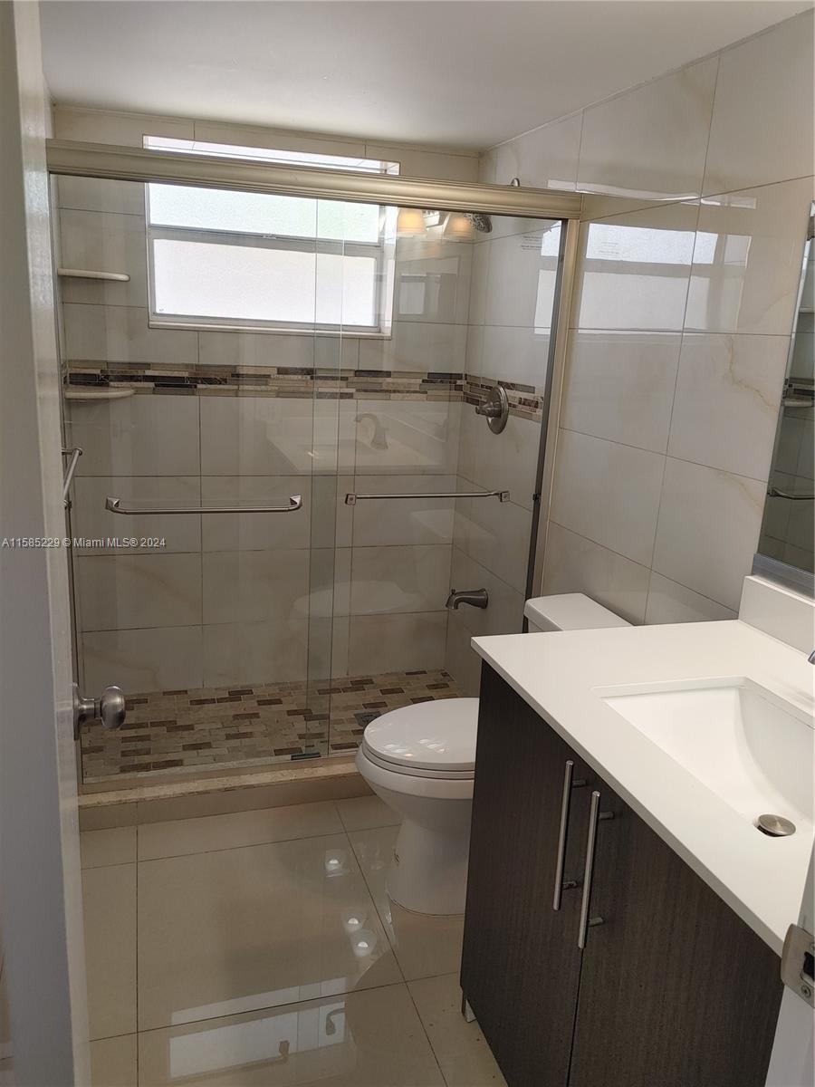 8330 Sands Point Boulevard, Unit N107 Tamarac, FL 33321 - Photo 11 of 13 a bathroom with a sink a toilet and shower