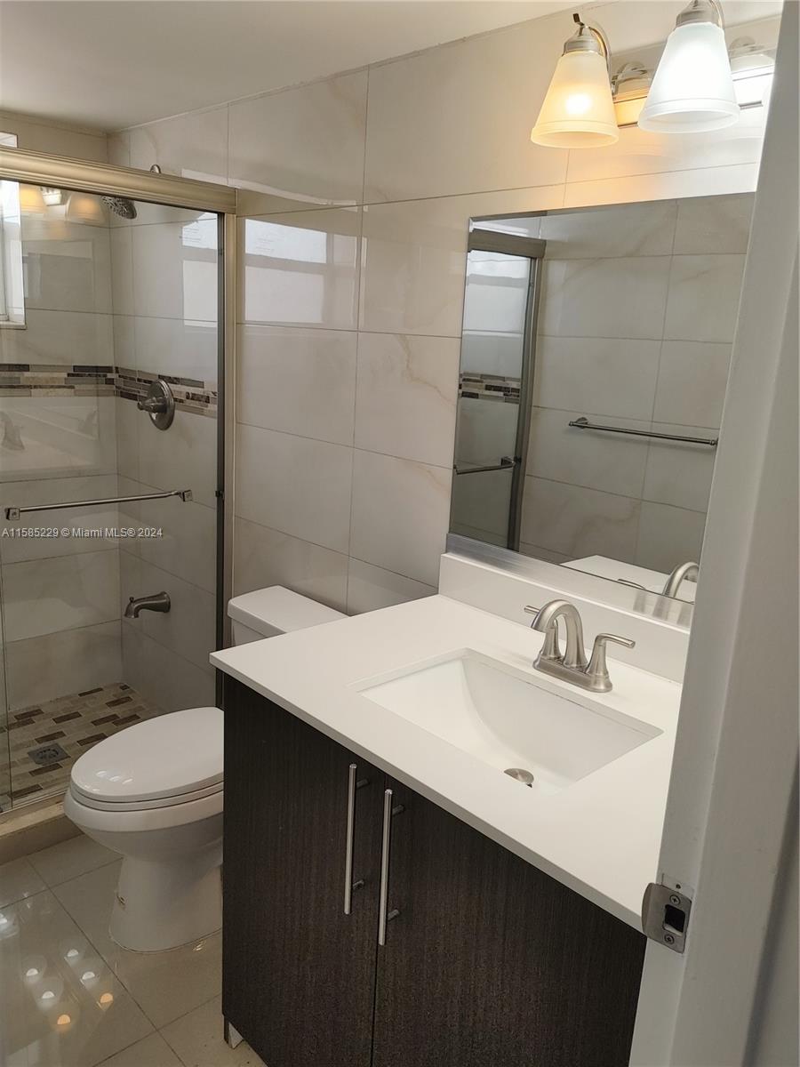 8330 Sands Point Boulevard, Unit N107 Tamarac, FL 33321 - Photo 12 of 13 a bathroom with a sink a toilet and shower