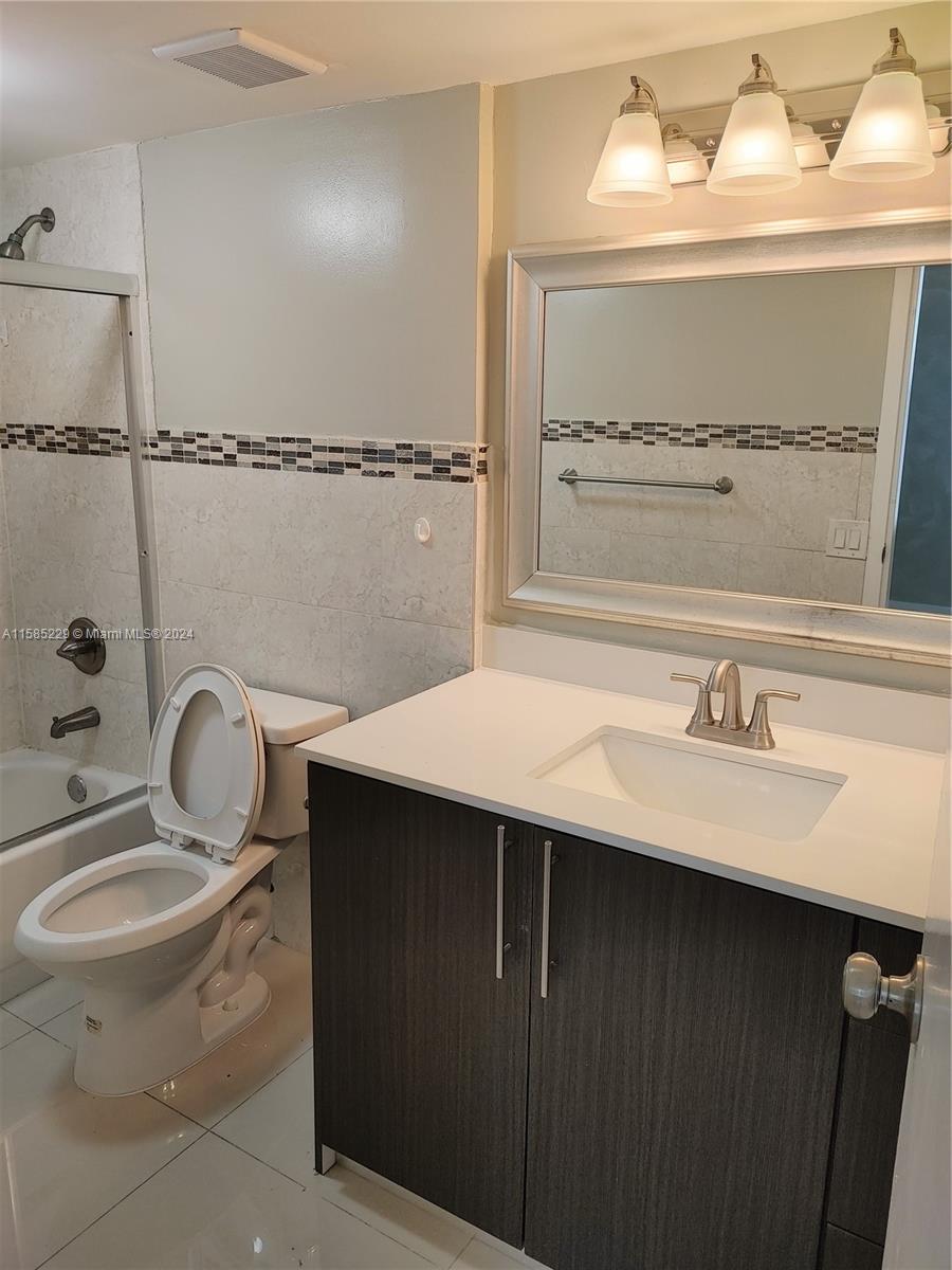 8330 Sands Point Boulevard, Unit N107 Tamarac, FL 33321 - Photo 13 of 13 a bathroom with a sink vanity mirror and toilet