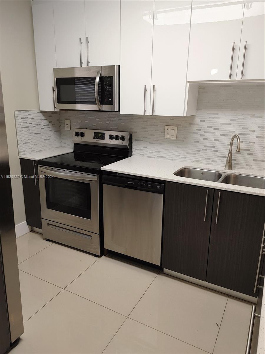 8330 Sands Point Boulevard, Unit N107 Tamarac, FL 33321 - Photo 3 of 13 a kitchen with granite countertop a sink and a microwave