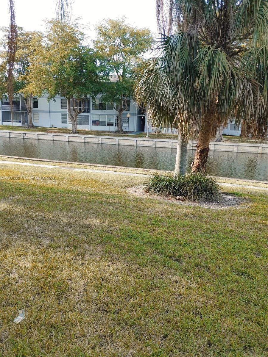 8330 Sands Point Boulevard, Unit N107 Tamarac, FL 33321 - Photo 7 of 13 a front view of house with yard and lake view
