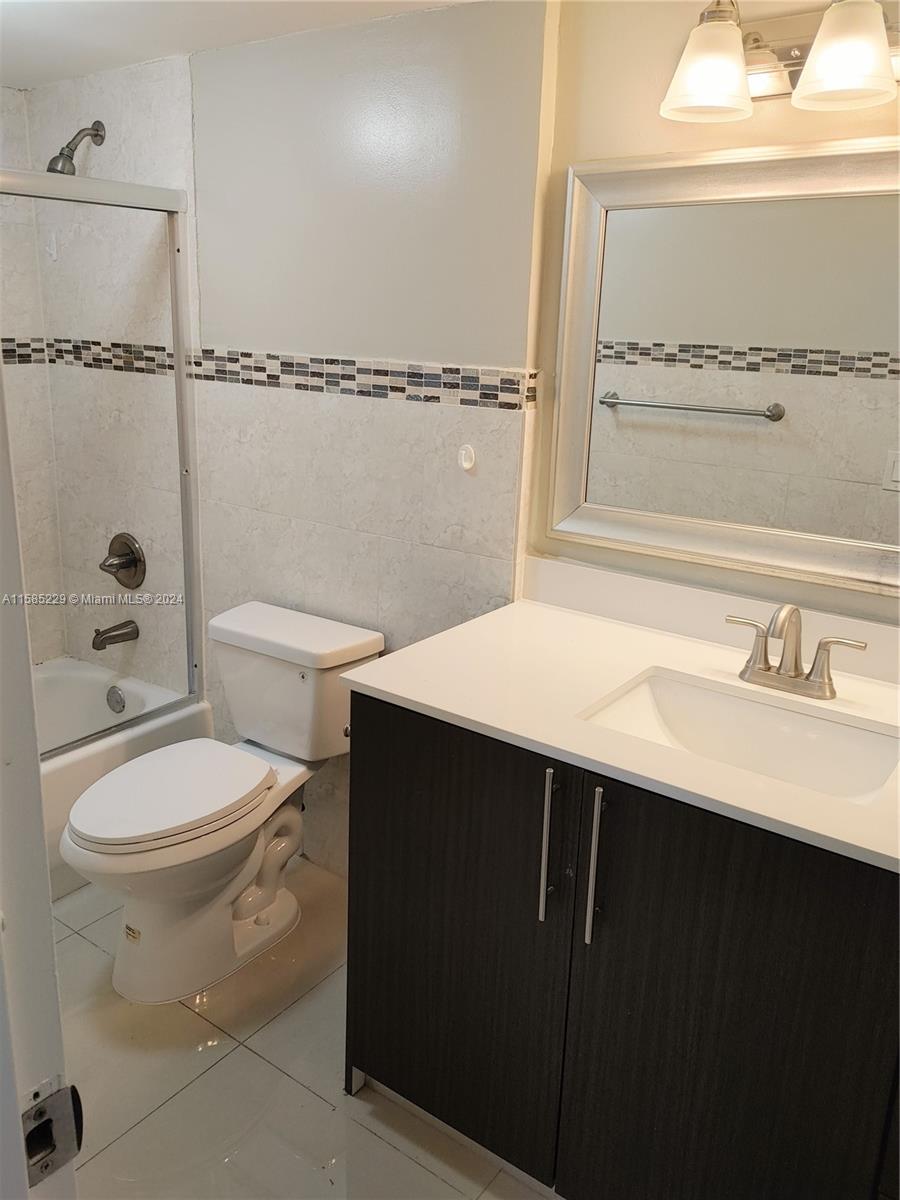 8330 Sands Point Boulevard, Unit N107 Tamarac, FL 33321 - Photo 9 of 13 a bathroom with a sink a toilet and shower