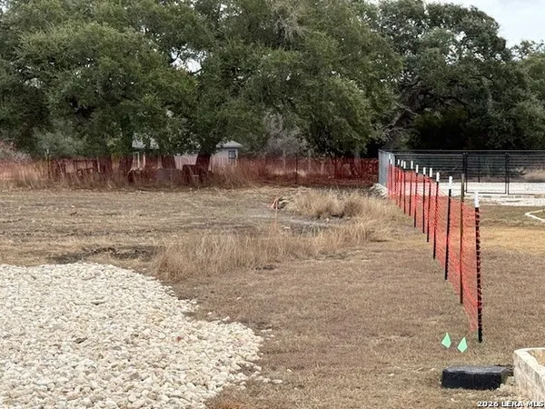 a view of a yard with wooden fence