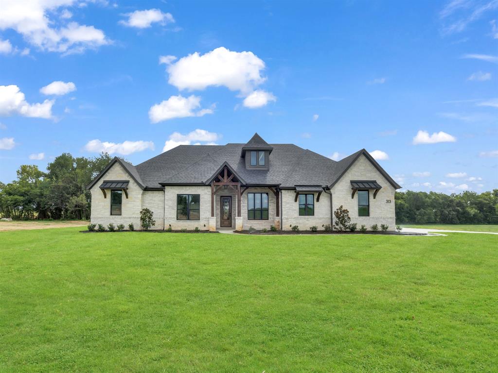 a front view of a house with a garden