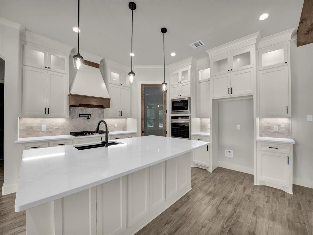 313 Wrangler Court Weatherford, TX 76088 - Photo 19 of 40 a kitchen with stainless steel appliances a refrigerator sink and white cabinets