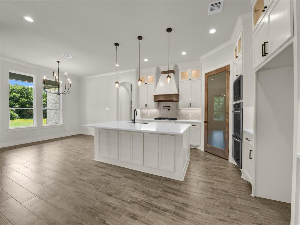 313 Wrangler Court Weatherford, TX 76088 - Photo 20 of 40 a kitchen with kitchen island white cabinets and stainless steel appliances