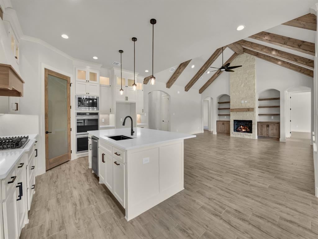 313 Wrangler Court Weatherford, TX 76088 - Photo 21 of 40 a large kitchen with stainless steel appliances granite countertop a stove and a wooden floors